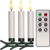 Three white LED candles with green bases and clips, alongside a remote control. Podgląd zdjęcia produktu