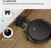 A black robot vacuum cleaner and its charging station are shown on a wooden floor. Náhled obrázku produktu