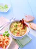A bowl of soup with bacon and bread on a blue wooden table. Produktbild-Vorschau