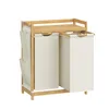 A laundry basket with two compartments and a shelf on top, made of bamboo and beige fabric. Náhled obrázku produktu