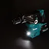 A cordless rotary hammer drill is shown against a dark background, with its LED light illuminating the foreground. Podgląd zdjęcia produktu