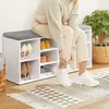 A person is sitting on a shoe cabinet with a padded seat and tying their shoes. Náhľad obrázku produktu
