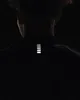 Close-up of the back of a person's neck and shoulders, wearing a black garment with reflective stripes. Náhled obrázku produktu