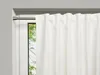 A white curtain is partially drawn across a window, revealing a glimpse of green trees outside. A silver curtain rod is visible at the top. Produktbild-Vorschau