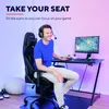 A man is playing a video game while sitting in a gaming chair in a room with colorful lighting. Voir les images du produit
