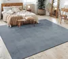 A bedroom with a bed, rug, and furniture. Anteprima dell’immagine prodotto