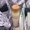 Close-up view of items inside a bag, including a water bottle, a phone, and notebooks. Anteprima dell’immagine prodotto