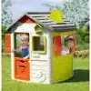 Two children are playing in a colorful playhouse in a grassy yard. Produktbild-Vorschau
