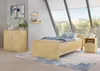 A bedroom with a wooden bed, nightstand, and dresser, featuring a large window with a view of trees. Produktbild-Vorschau