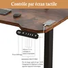 Close-up of a standing desk control panel with a phone charging on the desk. Voir les images du produit