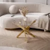 A modern living room scene featuring a gold and glass coffee table in front of a plush sofa. Produktbild-Vorschau