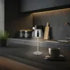 A modern kitchen counter with a small LED table lamp and a cup of coffee. Anteprima dell’immagine prodotto