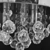A close-up view of a crystal chandelier with many faceted crystal spheres hanging from metal rings. Podgląd zdjęcia produktu