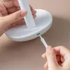 A close-up shot of hands plugging a white charging cable into a white device. Voir les images du produit
