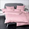 A neatly made bed with pink bedding and a grey headboard. Produktbild-Vorschau