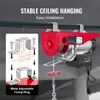 A red electric hoist is shown hanging from a ceiling beam, with a diagram illustrating its mounting system. Náhľad obrázku produktu