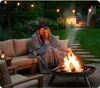 A couple sits on a couch wrapped in a blanket, enjoying a fire pit in their backyard at dusk. Náhľad obrázku produktu