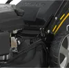 A close-up view of a lawnmower's engine and wheel. Produktbild-Vorschau