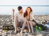 A couple enjoying music on the beach with two portable speakers. Produktbild-Vorschau