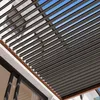 A close-up view of a modern pergola roof with adjustable louvers, showing the structure against a blue sky. Náhled obrázku produktu