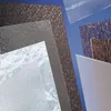 A collection of different textured plastic sheets arranged diagonally against a blue background. Produktbild-Vorschau