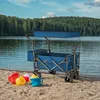 A blue wagon sits on a sandy beach next to a lake, with beach toys in the foreground. Voir les images du produit