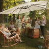 A group of people enjoying a gathering outdoors under a large cantilever umbrella. Voir les images du produit