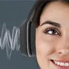 Close-up of a woman wearing headphones, with sound waves emanating from the headphones. Produktbild-Vorschau