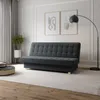 A modern living room with a sofa, floor lamp, and artwork.