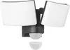 A dark gray LED floodlight with two adjustable heads and a motion sensor is shown against a white background. A separate, smaller white sensor cover is positioned below the main unit. Produktbild-Vorschau