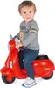 A young child is sitting on a red toy Vespa scooter. Náhľad obrázku produktu