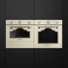 Two cream-colored Smeg ovens are shown side-by-side against a black background. Anteprima dell’immagine prodotto