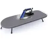 A blue and silver iron is steaming on a gray ironing board with black legs, set against a white background. Produktbild-Vorschau