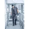 A man in workwear walks on a metal walkway. Anteprima dell’immagine prodotto