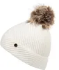 A white knitted beanie with a brown faux fur pom-pom is shown against a white background. Produktbild-Vorschau