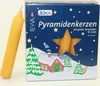 A box of yellow pyramid candles with a winter scene on the front, next to a single yellow candle. Produktbild-Vorschau