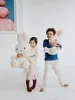 Two children holding large plush toys in a studio setting. Anteprima dell’immagine prodotto