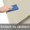 A hand is wiping a beige fabric with a blue cloth, indicating ease of cleaning. Náhled obrázku produktu