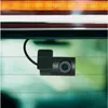 A dash cam mounted on the inside of a car's rear window. Produktbild-Vorschau