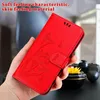 A hand holding a red phone case with a floral design. Produktbild-Vorschau