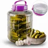 A large glass jar filled with pickles, with a few pickles and garlic bulbs in front of it. Produktbild-Vorschau