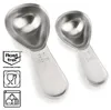 Two stainless steel measuring spoons are shown against a white background, with accompanying icons. Produktbild-Vorschau