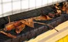 A close-up view of a gutter guard with leaves and twigs accumulated on it. Podgląd zdjęcia produktu