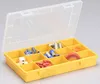 A yellow plastic organizer box with a clear lid, filled with various electrical connectors and a roll of red tape. Produktbild-Vorschau