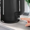 A close-up shot of a black electric kettle with a hand pressing the power switch. Produktbild-Vorschau