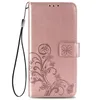 A pink phone case with a floral design and a wrist strap. Produktbild-Vorschau