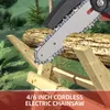 A cordless electric chainsaw is shown cutting through wooden beams in an outdoor setting with trees and grass. Podgląd zdjęcia produktu