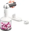 A hand holding a cordless hand blender with a chopping attachment filled with red onions, next to its charging base and power adapter. Náhled obrázku produktu