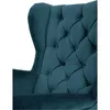 A close-up view of the tufted back and wing of a teal velvet armchair. Náhled obrázku produktu