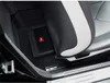 A compact JBL subwoofer is placed under the passenger seat of a car. Voir les images du produit
